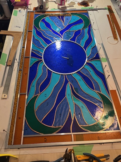 Blue and teal handcrafted stained-glass clock in progress